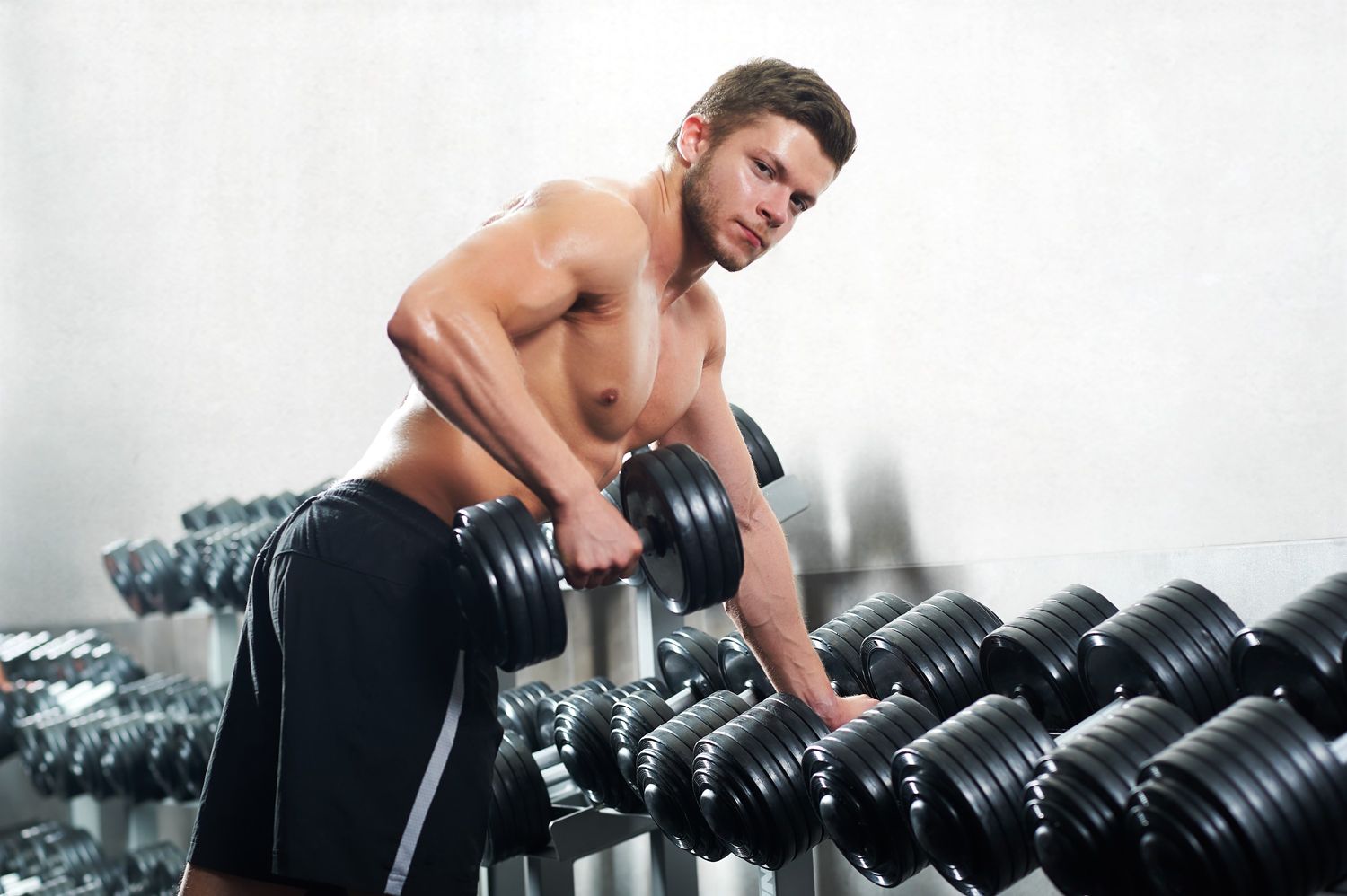 handsome-young-athlete-working-out-at-the-gym-54XWTB4