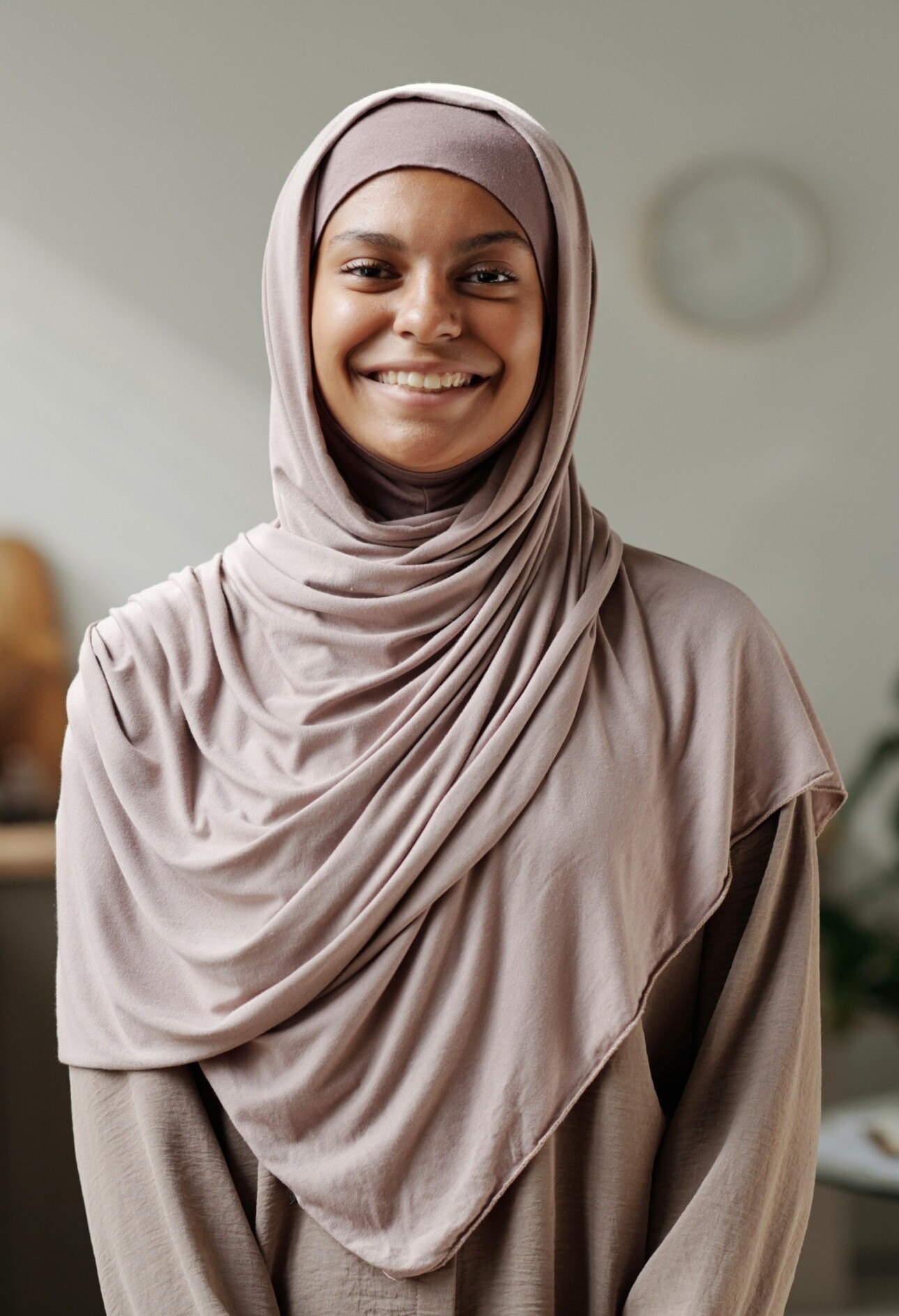 happy-young-muslim-woman-in-beige-hijab-standing-i-KTSQ929