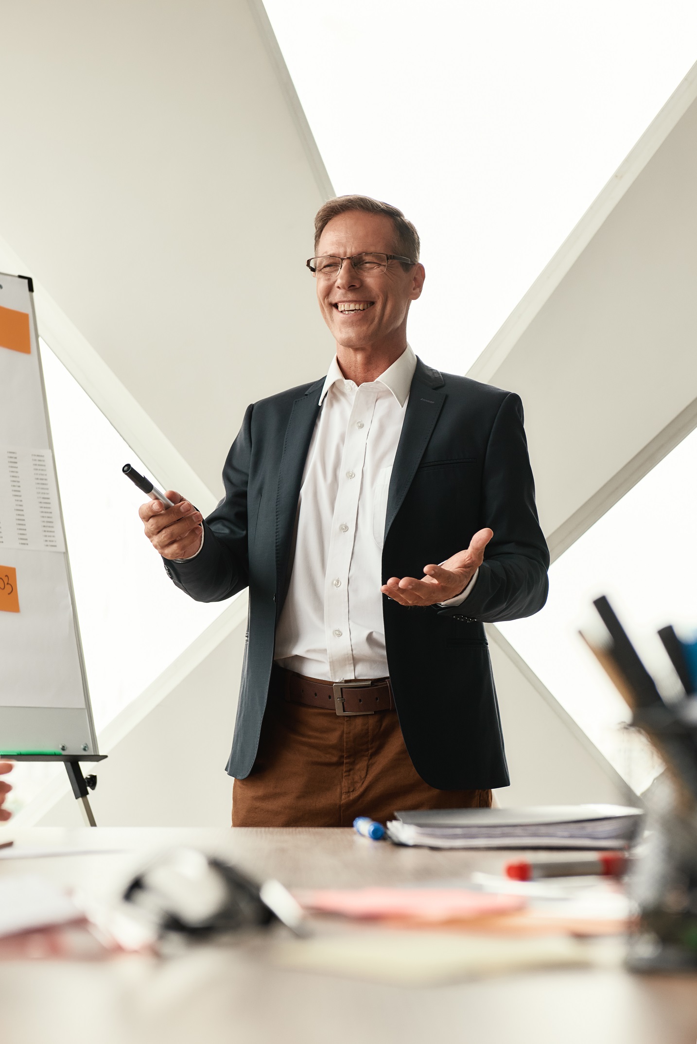 Best results Happy mature businessman in formal wear standing near whiteboard and smiling while working in the modern office. Business concept